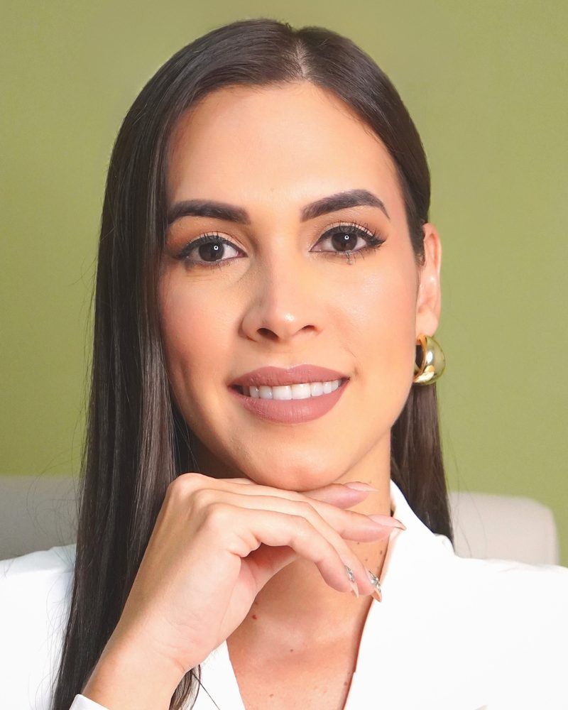 Retrato de la psicóloga Jaidelys Acevedo Valentín sonriendo, con la mano apoyada en la barbilla